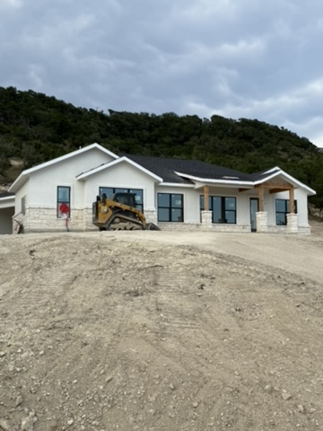 New home with light stone accents around the base and porch columns